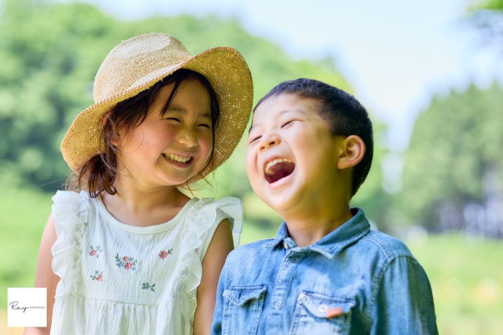 夏の屋外で大笑いする姉弟。水遊びの「楽しい!」が伝わる自然な表情