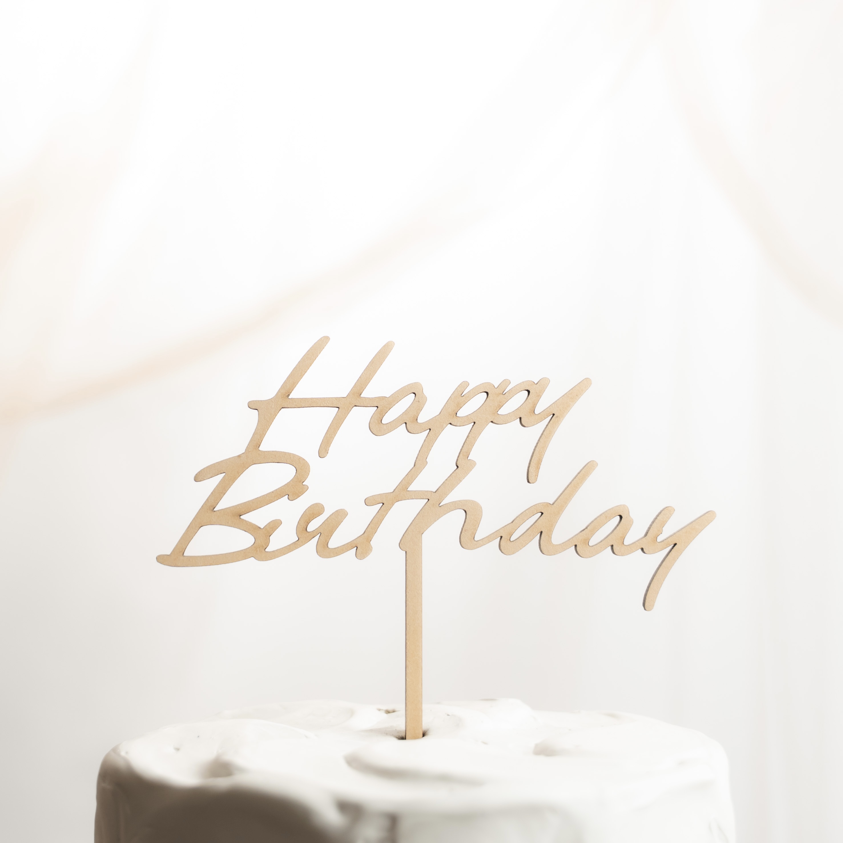 白いケーキにHappy Birthdayの木製ケーキトッパーを刺したバースデーフォト